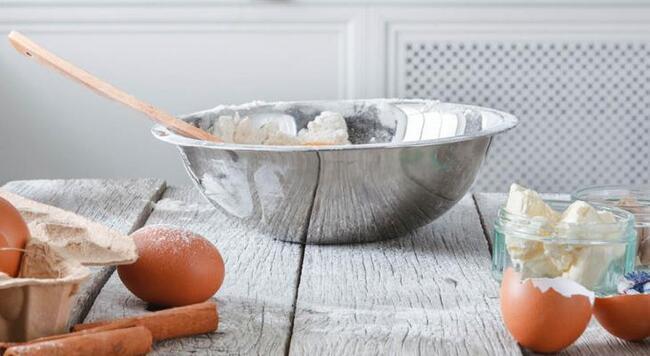 dough in mixing bowl on flour-covered counter with fresh eggs